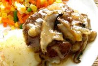 Crock Pot Salisbury Steak close up on a bed of mashed potatoes and gravy
