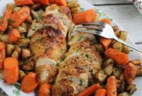 A platter of oven roasted split chicken breasts surrounded by roasted carrots and ranch potatoes.