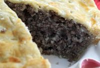 Tourtiere, French Meat pie with a slice removed revealing the filling inside.